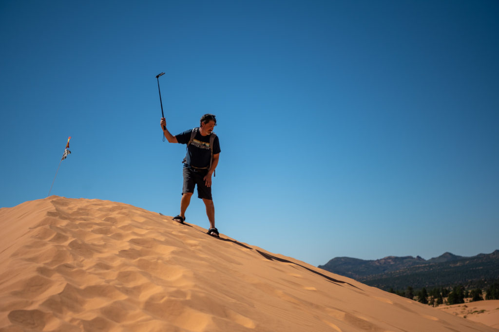 Tourist surfing pink coral sand dunes selfie stick