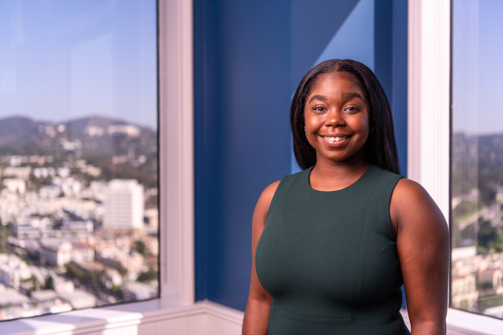 A female marketing executive environmental portrait in front of windows overlooking Hollywood from Santa Monica, Calif.